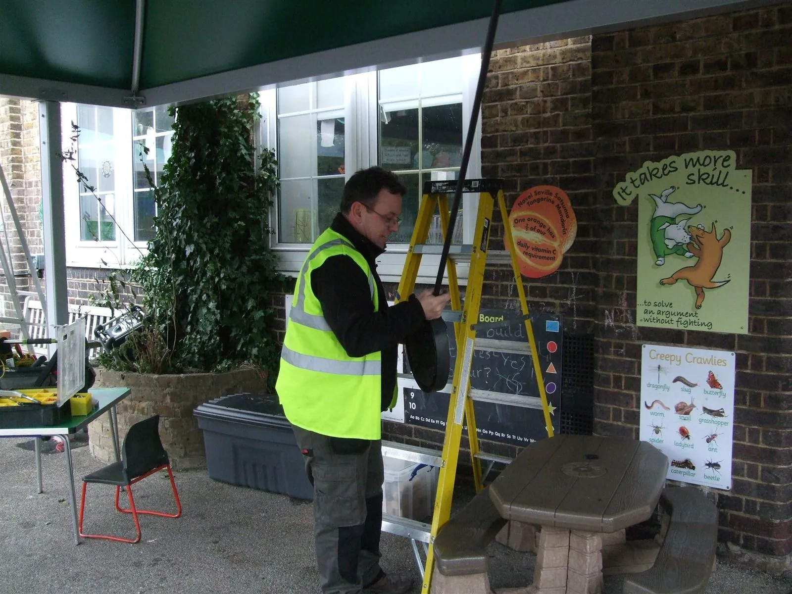 Electrician working above a covered building entrance