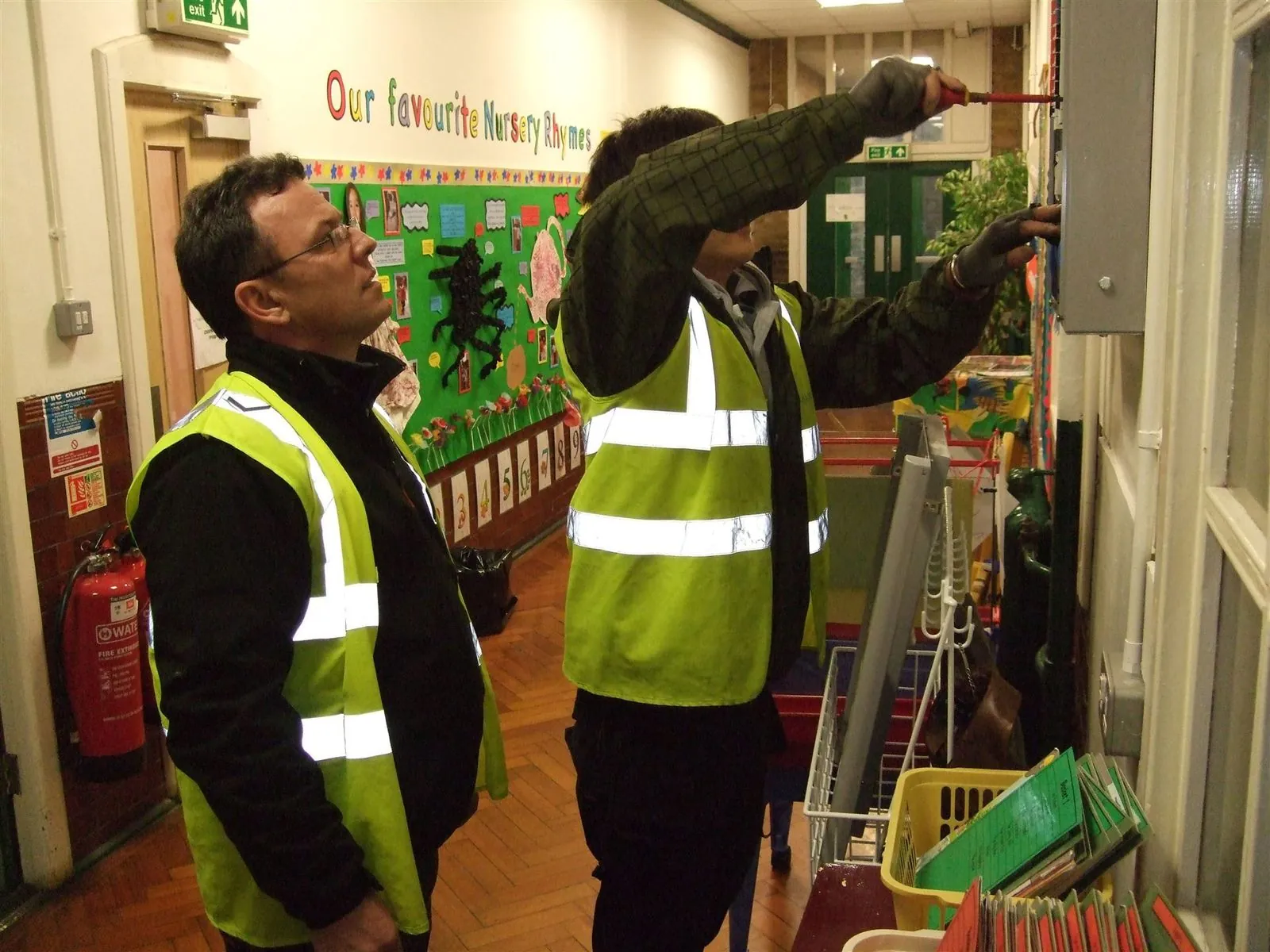 Electricians working at a distribution board on a commercial site