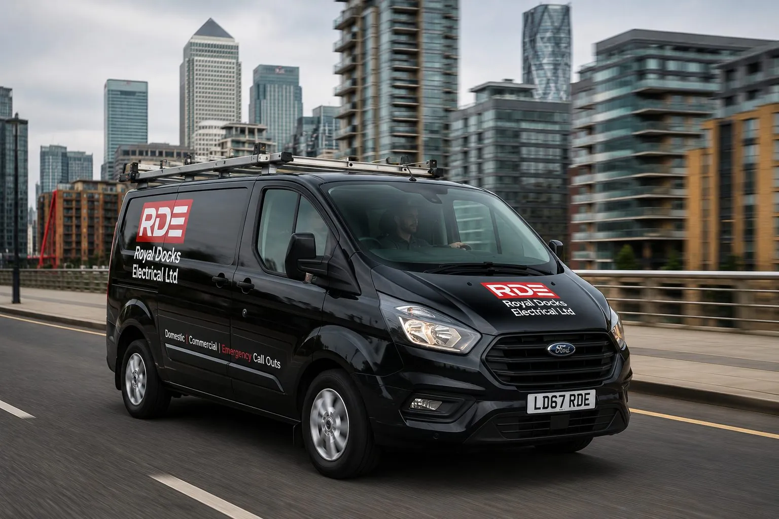 Royal Docks Electrical van on the road by the Canary Wharf skyline in East London