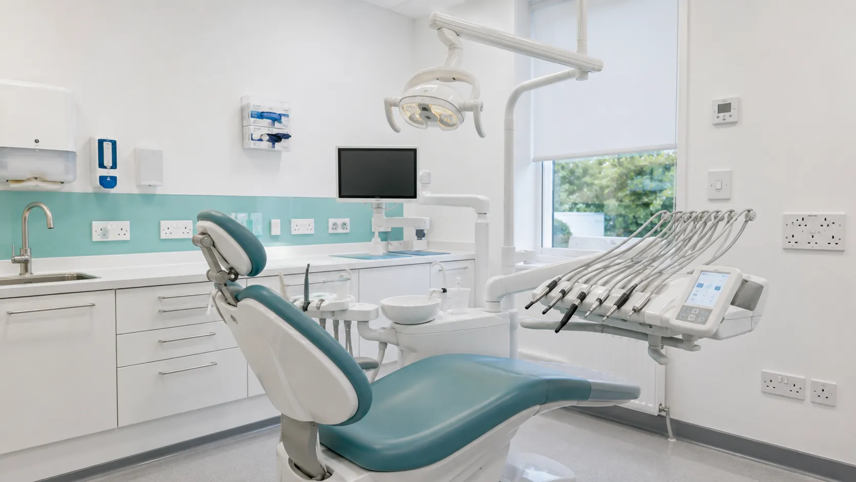 Modern dental surgery treatment room with electrical sockets and equipment